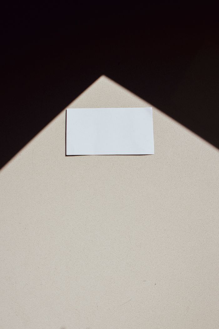 services-03 A minimalist photo of a blank business card with a geometric shadow, ideal for design concepts.